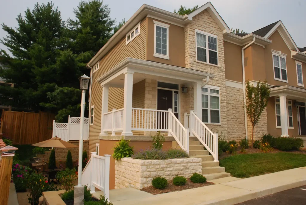 Two-story suburban townhouse with stone facade, porch, and front steps